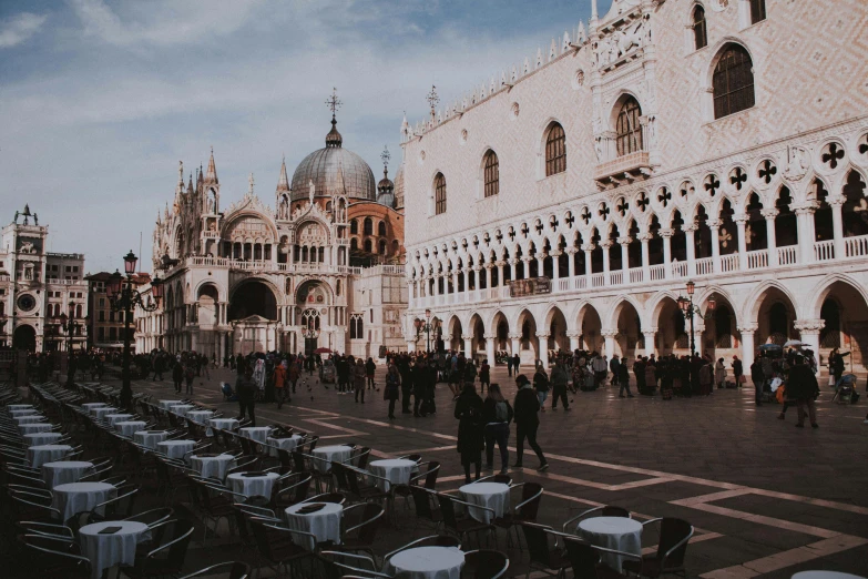 a crowd of people standing around tables and chairs, inspired by Quirizio di Giovanni da Murano, pexels contest winner, baroque, city view, square, white sweeping arches, gif