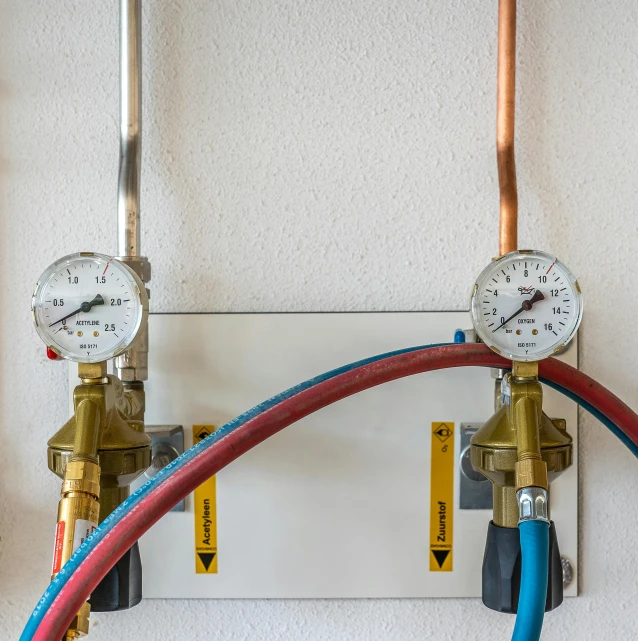 a couple of gauges sitting on top of a wall, with pipes attached to it, high-quality photo, detailed product image, homemade