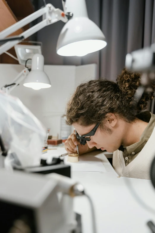 a man sitting at a desk in front of a computer, by Jacob Toorenvliet, pexels contest winner, specimens in glasses, carefully crafted, gif, plating