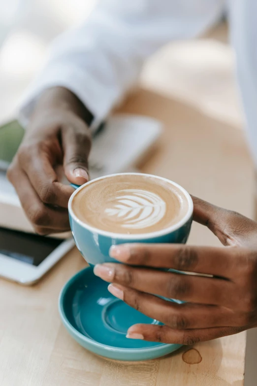 a close up of a person holding a cup of coffee, by Austin English, daily specials, thumbnail, cafe tables, creating a soft