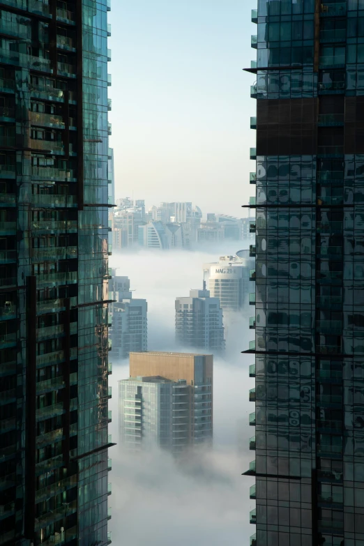 a couple of tall buildings sitting next to each other, a matte painting, by Doug Ohlson, pexels contest winner, swirling fog, canada, high angle shot, kan liu