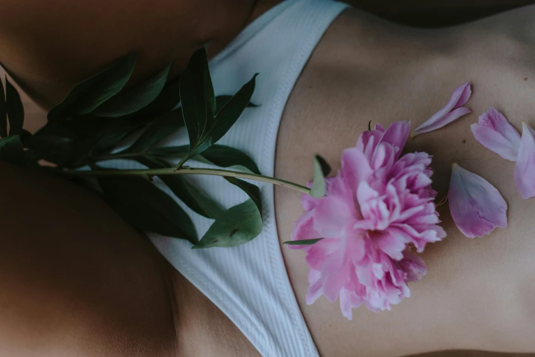 a woman with a flower on her stomach, trending on unsplash, aestheticism, wearing bra, peony flower, paradise garden massage, physical : tinyest midriff ever