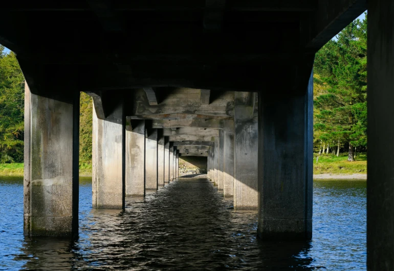 the underside of a bridge over a body of water, concrete pillars, amanda lilleston, multiple stories, portlet photo