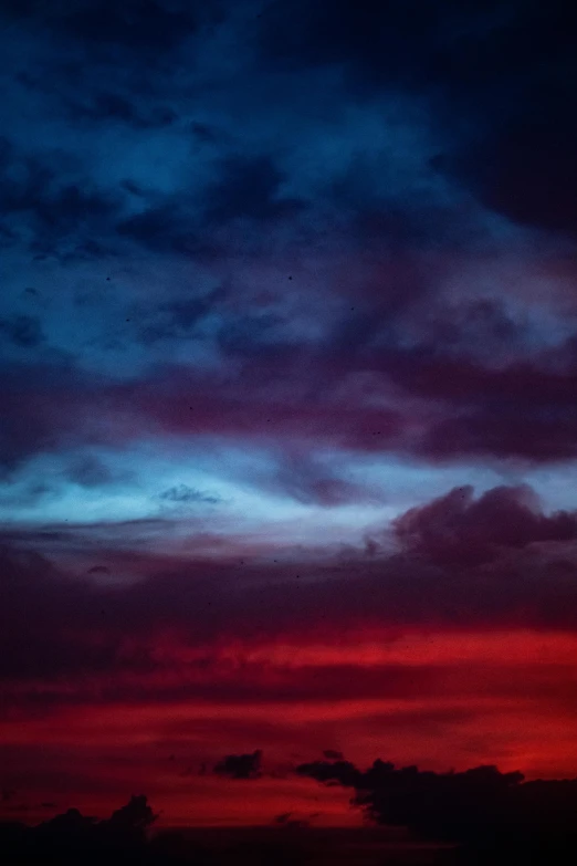 a red and blue sky with clouds in the background, unsplash, midnight colors, cinematic shot ar 9:16 -n 6 -g, color photography, indigo and venetian red