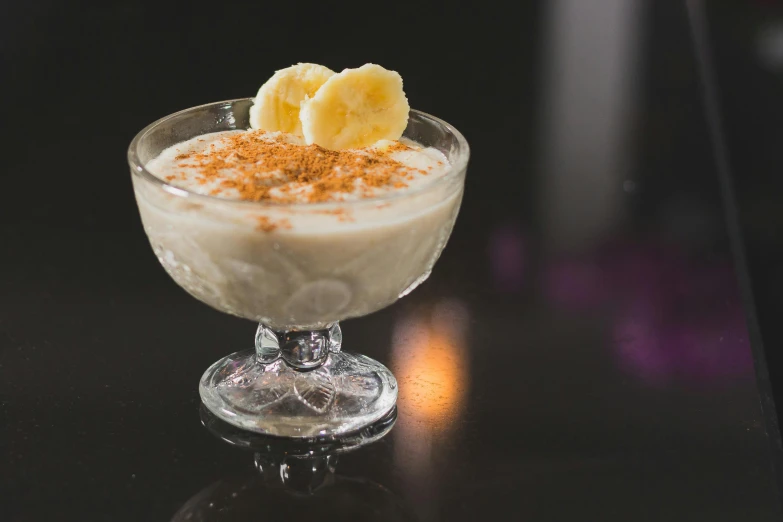 a close up of a dessert in a glass on a table, banana, press shot, paisley, creamy skin