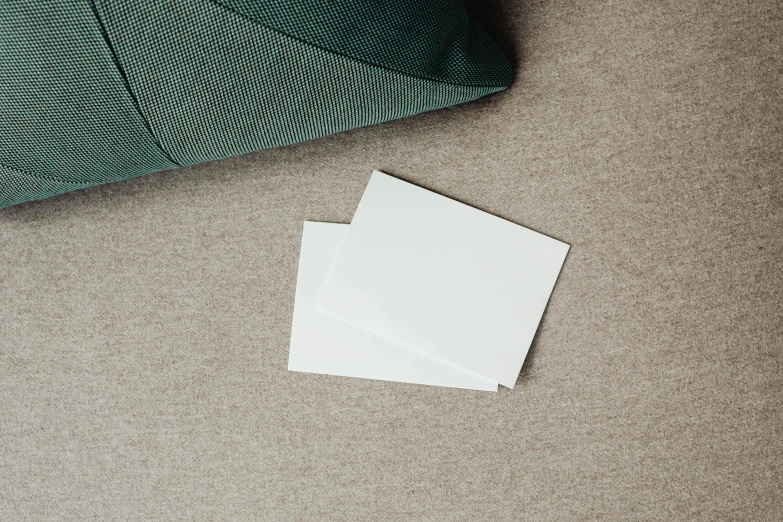 a piece of paper sitting on the floor next to a pillow, product view, cushions, white panels, two