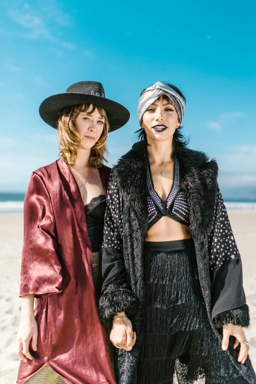 two women standing next to each other on a beach, a portrait, unsplash, renaissance, dressed in velvet, roaring 20s, official store photo, metal garments