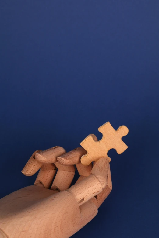 a wooden hand holding a piece of a puzzle, by artist, unsplash, conceptual art, with a blue background, modeled, 15081959 21121991 01012000 4k, technologies