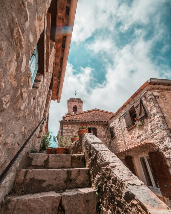 stairs leading up to a stone building with a clock tower in the background, pexels contest winner, romanesque, view of villages, thumbnail, bright sky, shady alleys