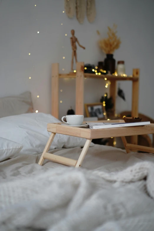 a tray that is sitting on top of a bed, pexels contest winner, light wood, small and cosy student bedroom, belle, sitting on a table