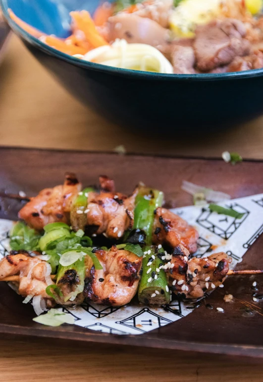 a close up of a plate of food on a table, chopsticks, grilled chicken, square, medium-shot