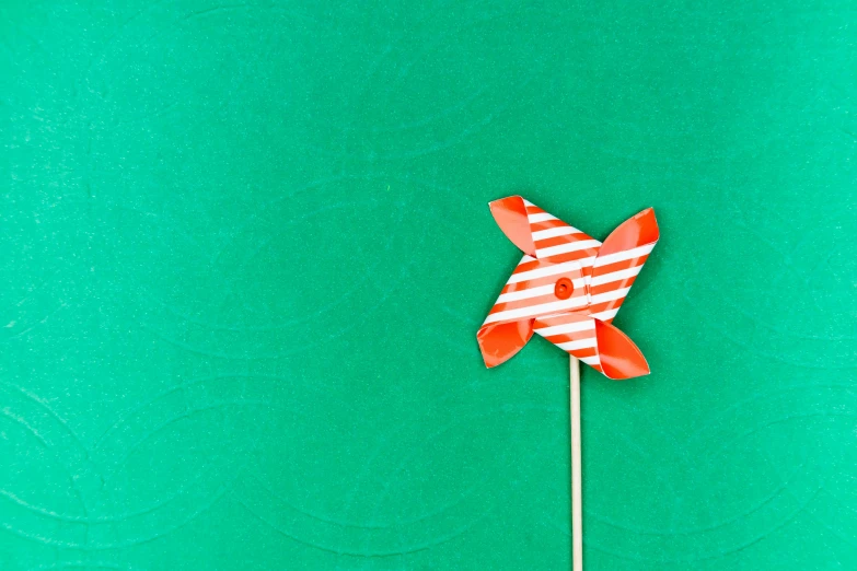 a red and white striped pinwheel on a stick, an album cover, pexels contest winner, postminimalism, green screen, paper craft, teal paper, windmill