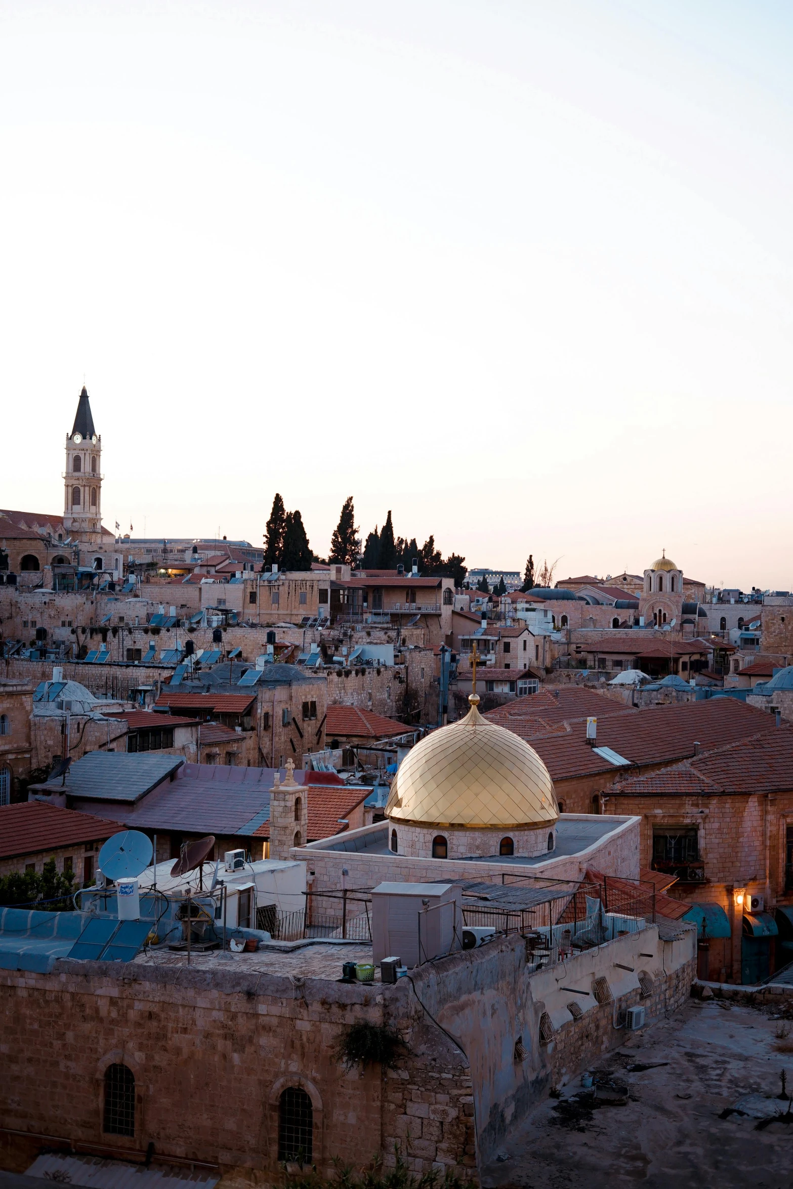 a view of a city from the top of a hill, by Leo Michelson, happening, black domes and spires, during golden hour, middle eastern, tiled roofs