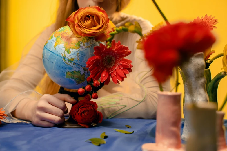 a woman holding a globe with flowers in it, an album cover, pexels contest winner, on a table, profile image, crafts, colored photo
