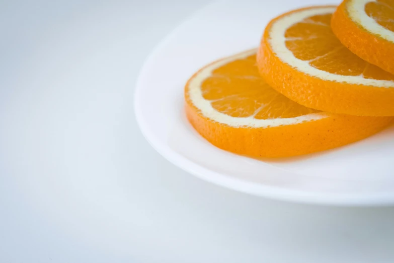 a white plate topped with slices of oranges, by David Simpson, pexels, photorealism, minimal. sharp focus, stacked image, round-cropped, soft rim light