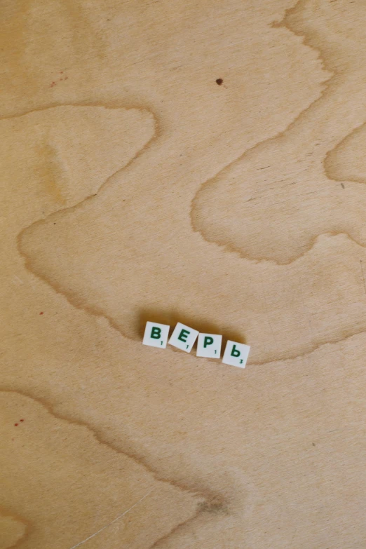 a couple of scrabbles sitting on top of a wooden table, by Henryka Beyer, unsplash, serial art, 000 — википедия, ussr, vanilla, detail shot