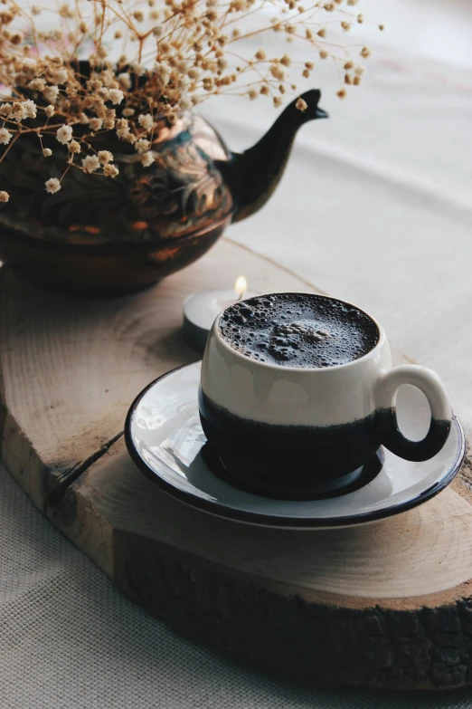 a cup of coffee sitting on top of a saucer, a still life, by Lucia Peka, unsplash, made of tar, cozy candlelight, powder, sichuan