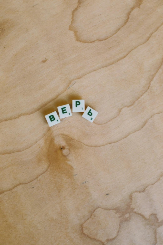 a couple of letters sitting on top of a wooden table, by Bertalan Pór, unsplash, letterism, square shapes, ussr, bumps, 000 — википедия