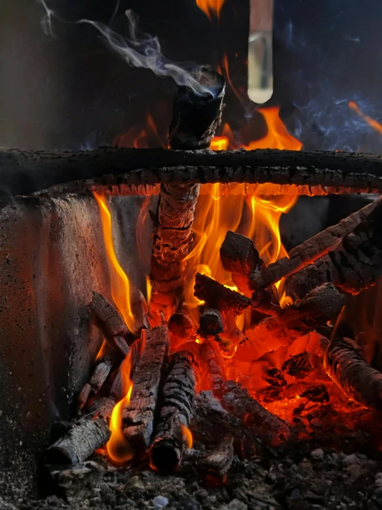 a close up of a fire in a grill, by Daniel Lieske, pexels contest winner, renaissance, winter setting, avatar image, multiple stories, large black kettle on hearth