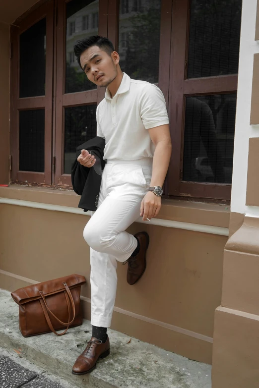 a man sitting on a ledge next to a building, inspired by Henric Trenk, instagram, white soft leather model, jakarta, brown:-2, dressed in white