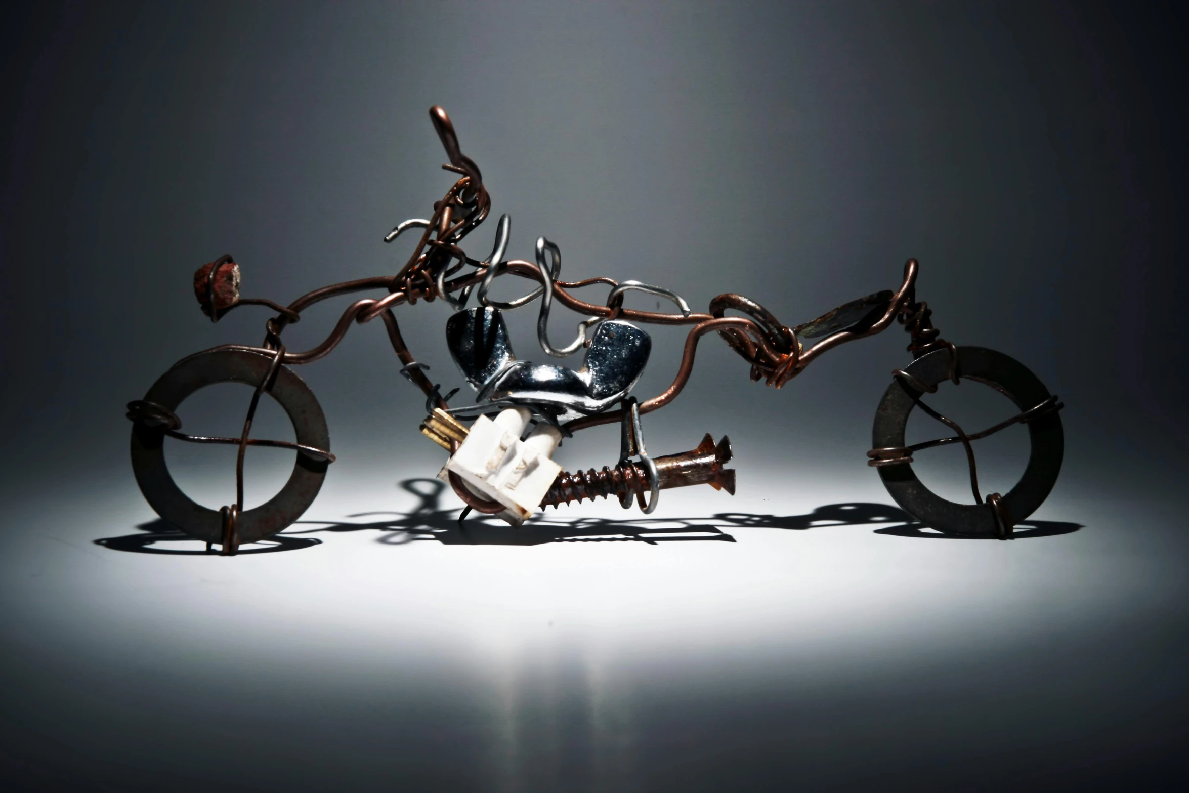 a sculpture of a motorcycle sitting on top of a table, inspired by Hendrick Cornelisz Vroom, unsplash, kinetic art, ilustration, burnt, fiona staples, masanori warugai