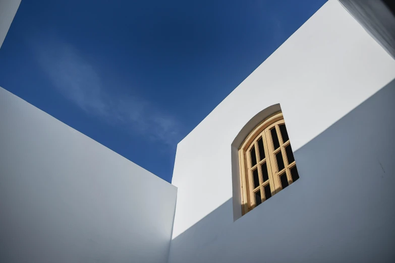 a window in a white building with a blue sky in the background, inspired by Ben Nicholson, unsplash contest winner, cyprus, lpoty, exterior photo, ochre