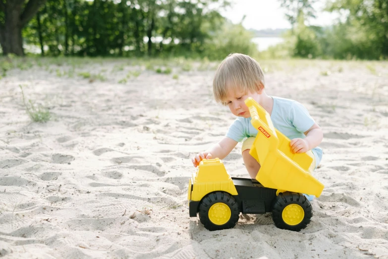 a little boy playing in the sand with a toy truck, a picture, by Andries Stock, unsplash, figuration libre, dhl yellow dhl van and the lake, high resolution product photo, on the concrete ground, high quality screenshot