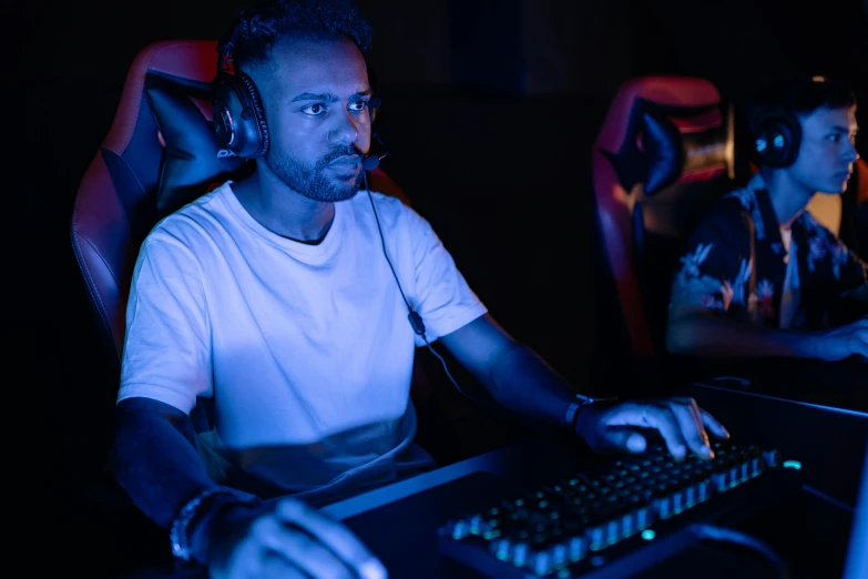 a man wearing headphones sitting in front of a computer, sierra entertainment games, blue and red lights, profile image, tournament