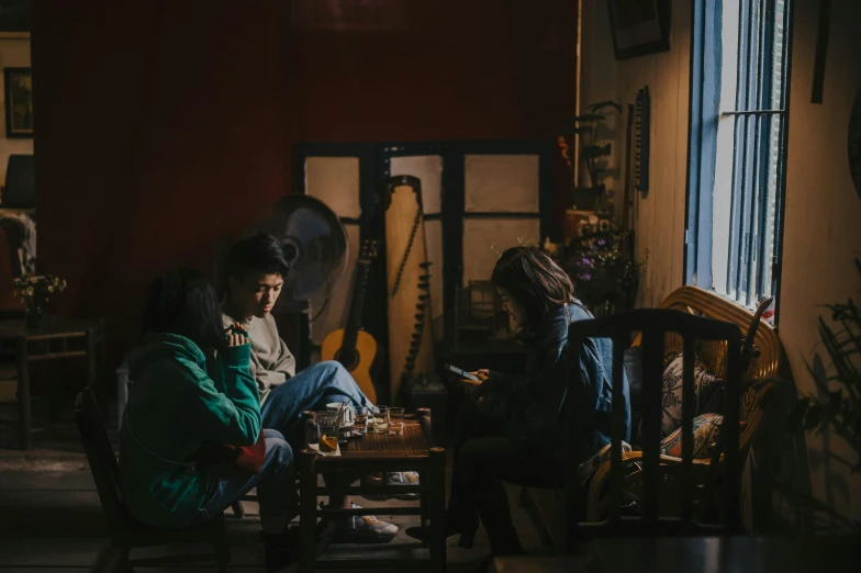 a group of people sitting around a table in a room, by Elsa Bleda, pexels contest winner, realism, coffee and musical instrument, teenager hangout spot, hoang lap, cinematic. by leng jun
