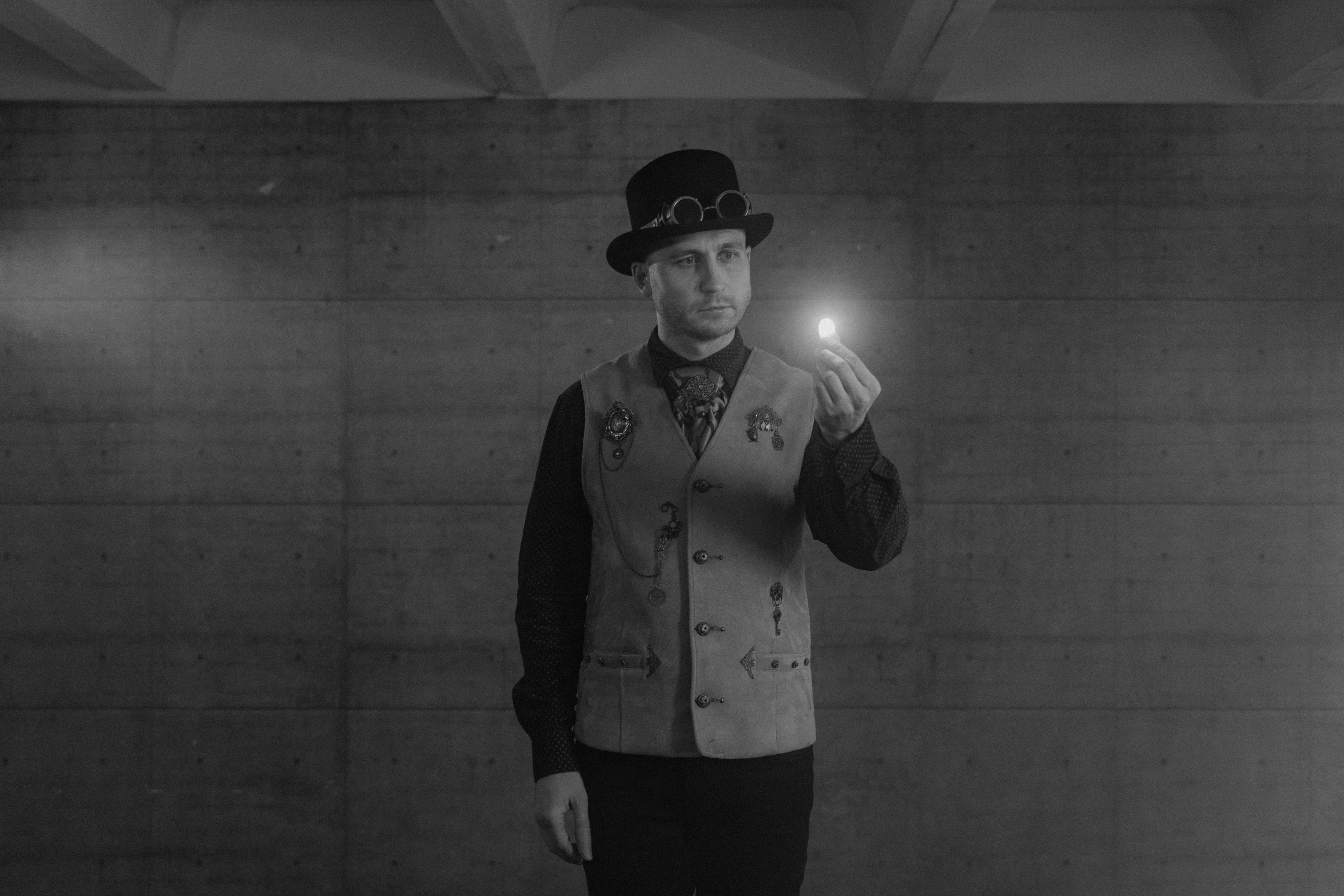 a black and white photo of a man in a top hat and vest, unsplash, bauhaus, holding a glowing orb, steampunk superhero, light mode, video