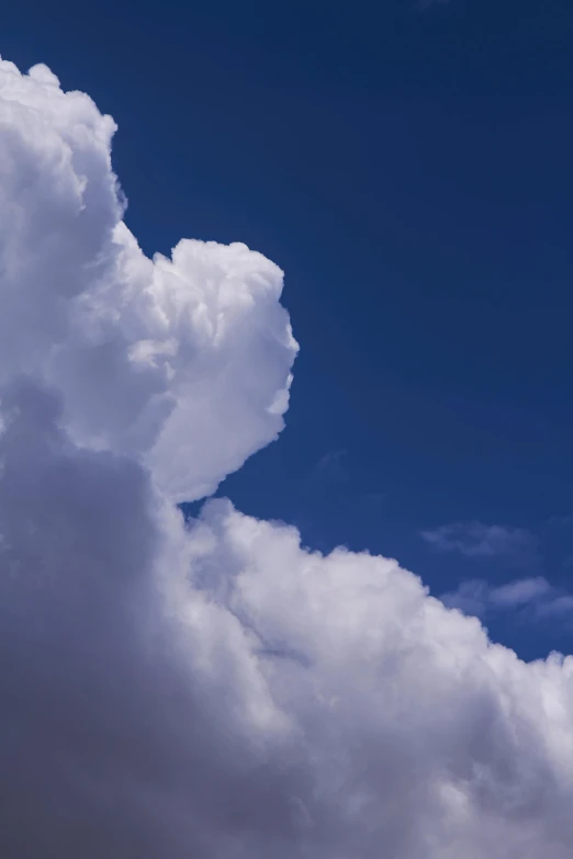 a jetliner flying through a cloudy blue sky, by Doug Ohlson, romanticism, towering cumulonimbus clouds, close - up photograph, color photograph, white cloud hair