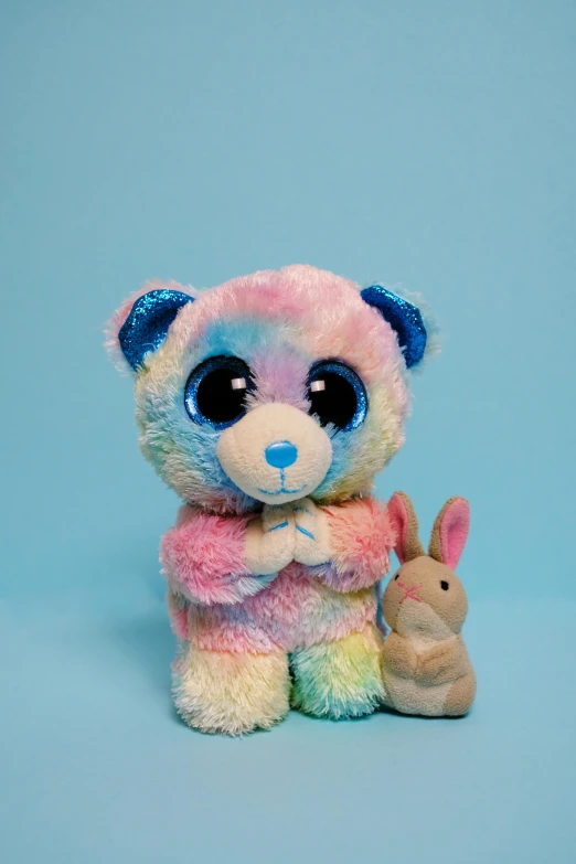 a couple of stuffed animals sitting next to each other, a picture, blue and pink, slide show, holy aura, multi colored