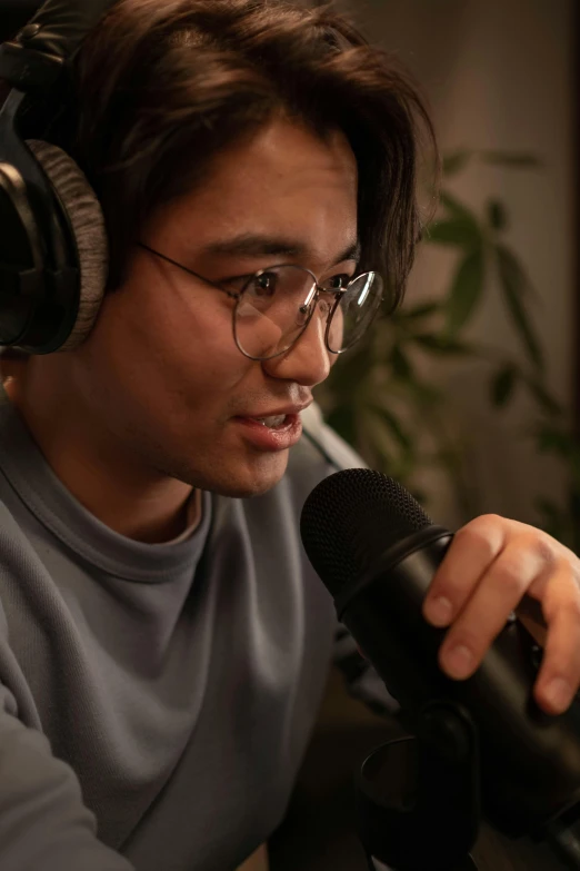 a man wearing headphones sitting in front of a microphone, wlop and ross tran, (((luke chueh))), zoomed in, lachlan bailey