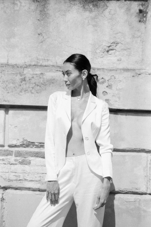 a black and white photo of a woman in a suit, inspired by Helmut Newton, wearing white suit, in a sunny day, a young asian woman, with a ponytail