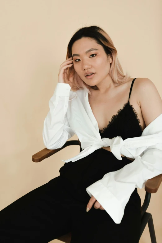 a woman sitting on a chair wearing a white shirt and black pants, inspired by Xia Chang, trending on pexels, bralette, wearing a nightgown, product introduction photo, asian descent