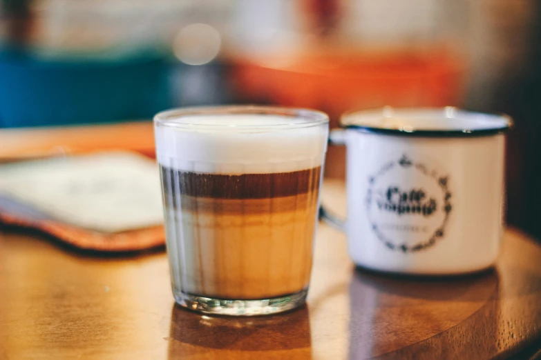 a cup of coffee sitting on top of a wooden table, profile image