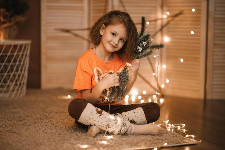 a little girl sitting on the floor in front of a christmas tree, pexels contest winner, orange glow, very beautiful cute catgirl, avatar image, girls