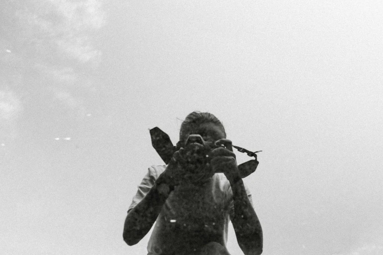 a black and white photo of a man holding a camera, by Caroline Mytinger, soaked, vastayan, hunting, seen from below