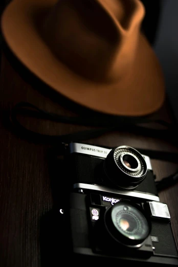 a hat sitting on top of a wooden table next to a camera, by Sven Erixson, nightcap, indoor picture