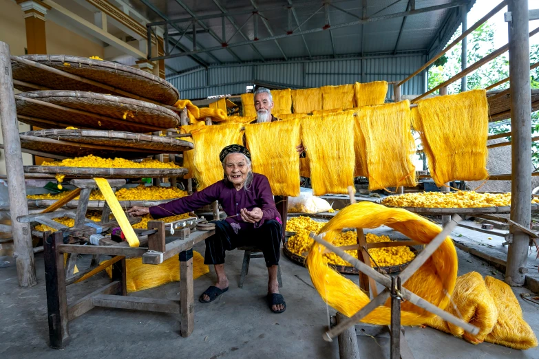 a man that is sitting in front of some yellow stuff, inspired by Ruth Jên, process art, traditional tai costume, small manufacture, warping, thumbnail