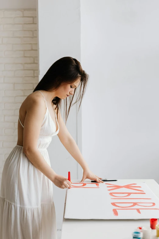 a woman in a white dress painting on a canvas, a silk screen, pexels contest winner, red writing, clean minimalist design, tabletop model, making out