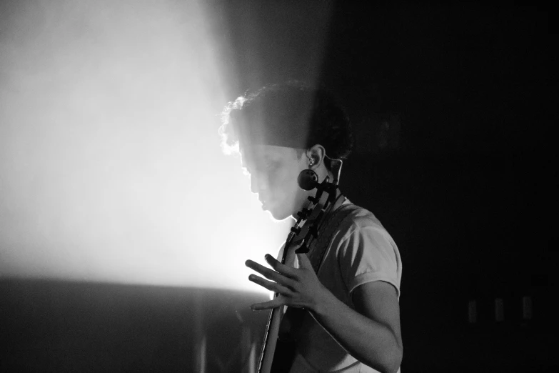 a man that is standing in front of a microphone, a black and white photo, by Ottó Baditz, light over boy, bassist, backlit ears, focused on neck