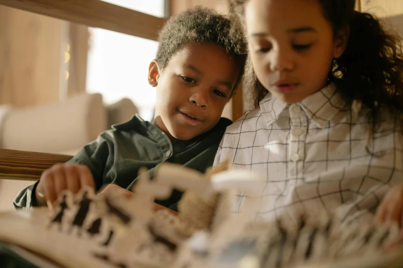 two children sitting on a couch reading a book, pexels contest winner, visual art, wooden art toys on base, architect, varying ethnicities, closeup portrait