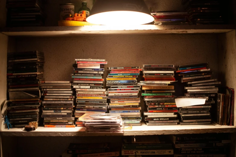 a shelf that has a lot of dvds on it, an album cover, unsplash, in a basement, ignant, play of light, very old