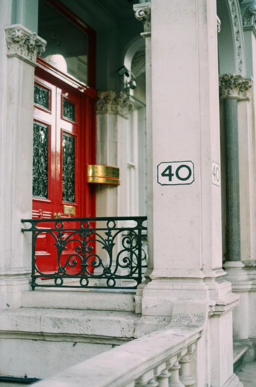 a red door sitting on the side of a building, pexels contest winner, art nouveau, 40 years old women, on a great neoclassical square, numerical, 4 0 years old