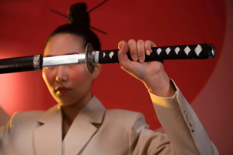 a woman holding a sword in front of her face, an album cover, inspired by Kanō Hōgai, unsplash, hito steyerl, close - up studio photo, shot with sony alpha 1 camera, avatar image