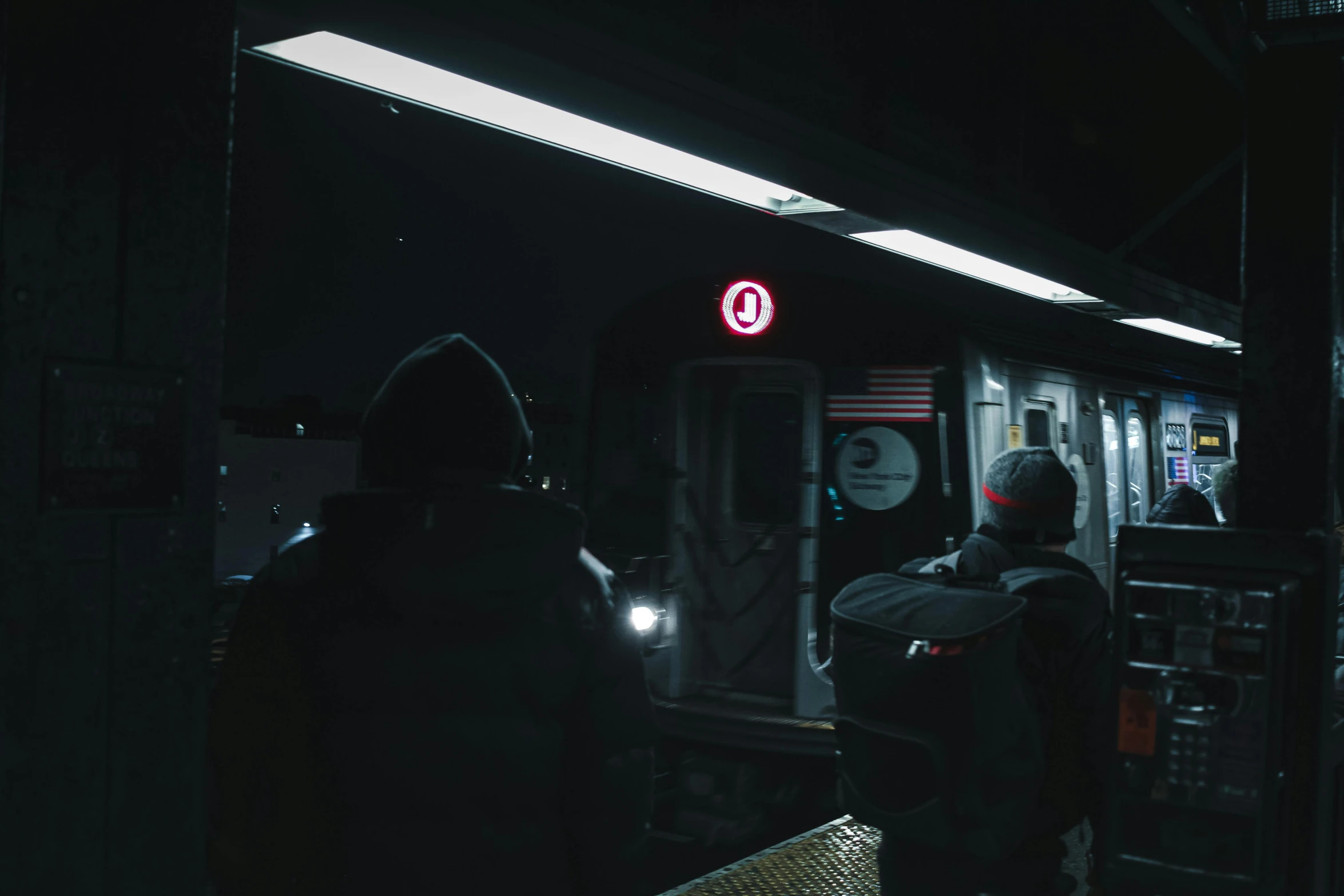 a couple of people that are standing in front of a train, by Elsa Bleda, night time footage, mta subway entrance, distant hooded figures, 🦑 design
