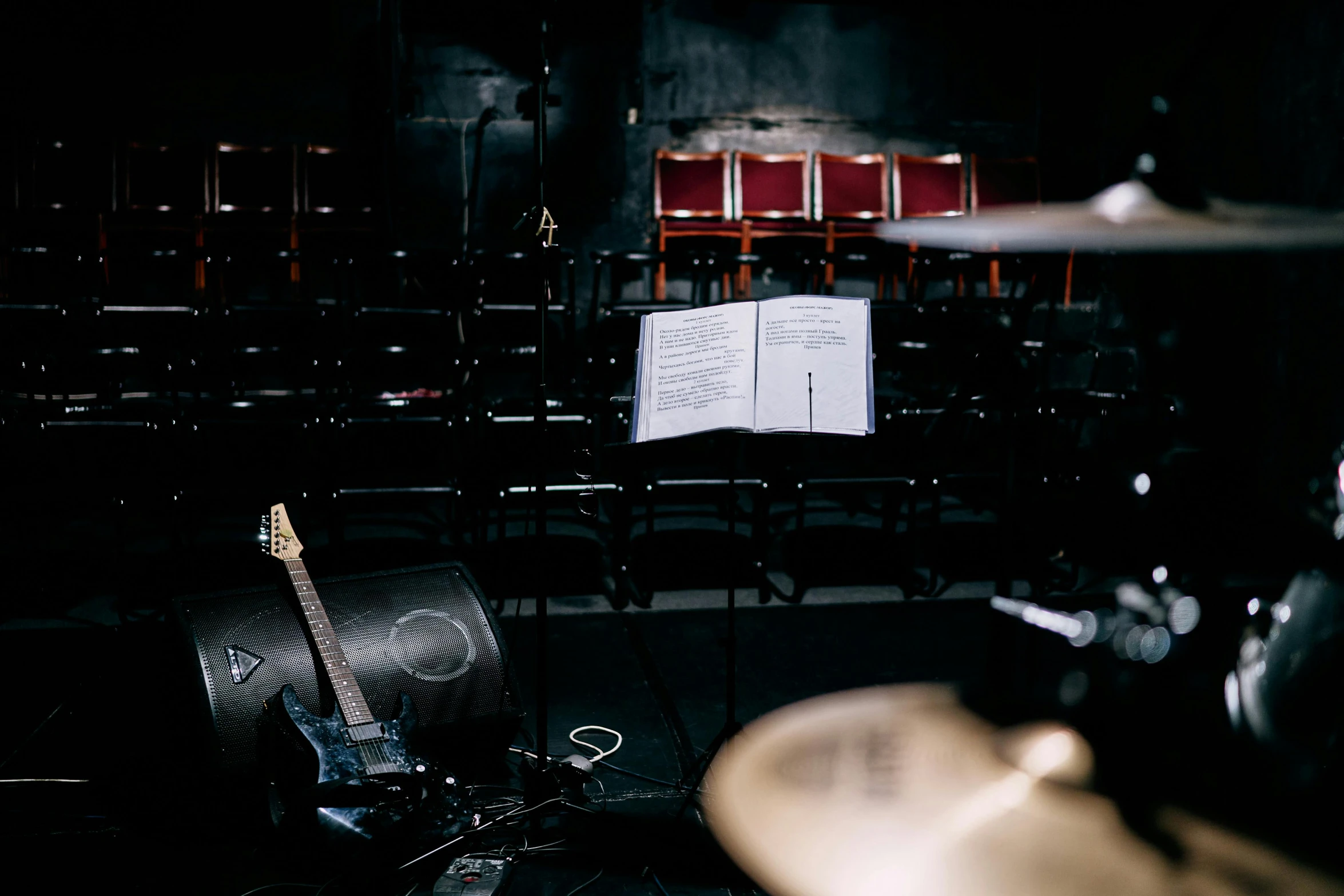 a group of musical instruments sitting on top of a stage, an album cover, by Glennray Tutor, unsplash, footage of a theater stage, background image, sydney hanson, ground - level medium shot