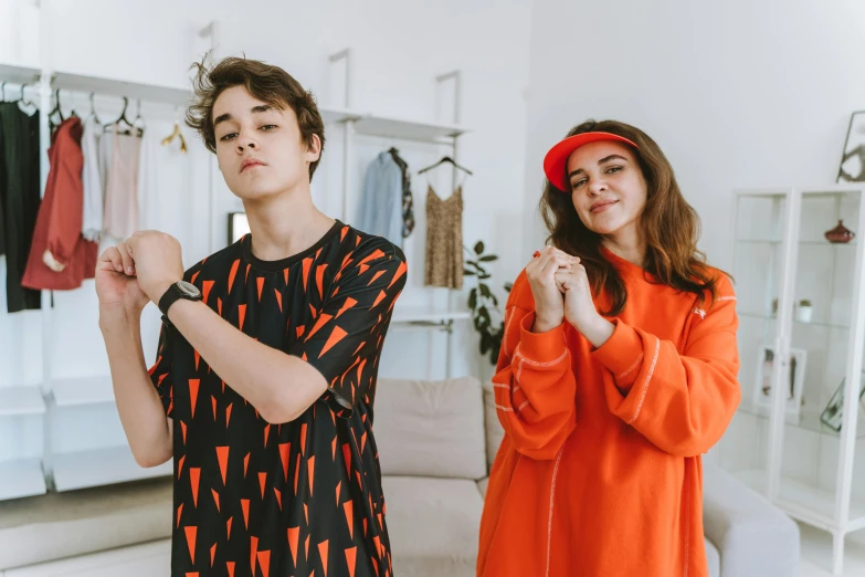 a couple of people standing next to each other, trending on pexels, orange robe, teenage boy, doing a sassy pose, wearing pajamas