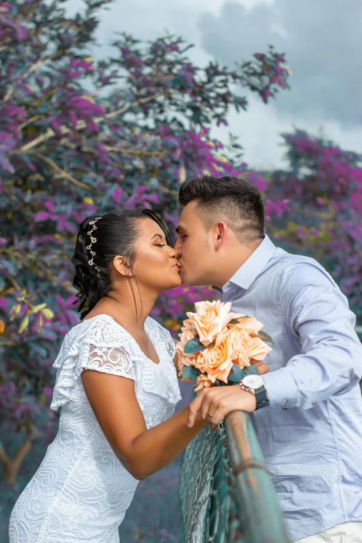 a bride and groom kissing on a bridge, a colorized photo, pexels contest winner, colombian, headshot profile picture, square, purple flower trees